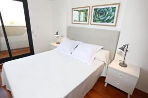 耶克拉Alojamientos Libertad的白色的卧室设有白色的床和窗户。