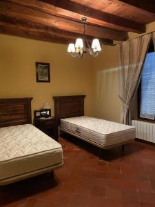 Siete Iglesias de TrabancosCasa Rural Calderon de Medina I y II的一间卧室配有两张床和吊灯。