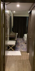 哈萨棕榈百合套房酒店的一间带盥洗盆和椅子的浴室