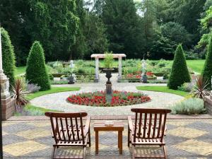 拉伦Amsterdamgarden - Nardinclant - Laren NH的花园设有两把椅子和一张桌子,花园内设有喷泉