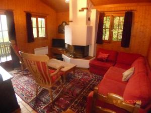 格吕耶尔Charming chalet with panoramic view and private garage in Gruyère的客厅配有红色的沙发和椅子