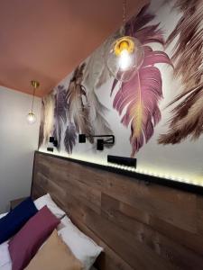 普乔雷Отель Сова的卧室墙上挂有羽毛壁画