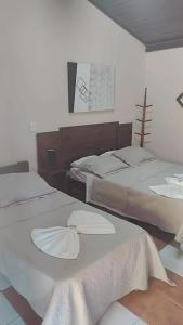 布罗塔斯Pousada Boa Vista的一间卧室配有两张带白色床单的床