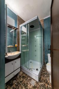 布什泰尼Suru Hotel & Restaurant的带淋浴、盥洗盆和卫生间的浴室