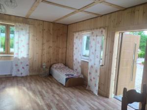 DubeninkiPrzy Trójstyku的卧室配有一张床铺,位于带木墙的房间内
