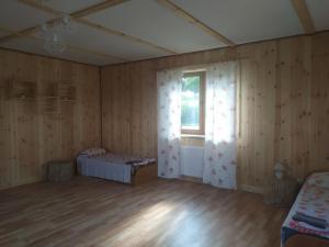 DubeninkiPrzy Trójstyku的客房设有带木墙和窗户的卧室。