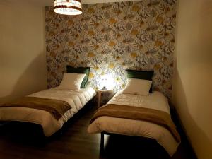 Launois-sur-VenceLe Petit Relais de Launois的配有2张单人床的带墙壁客房