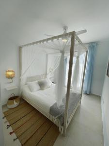 科斯塔巴伦娜Costa Ballena - Playa Azul Beach House的客房内的白色床和天蓬