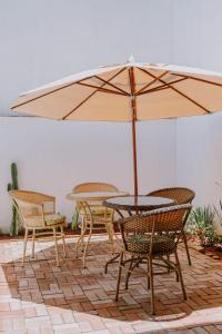 卡波布里奥Pousada Velas do Forte的庭院内桌椅和遮阳伞