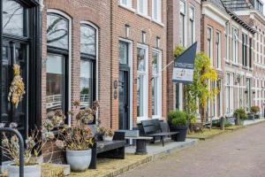 多克姆Stadslogement Het Keerpunt Dokkum的街道上一排长椅和植物的建筑