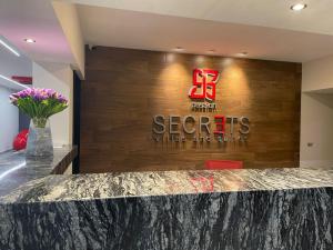 托卢卡HOTEL PASSION SECRETS VILLAS AND SUITES的大堂设有读秘密葡萄酒和烈酒的标志