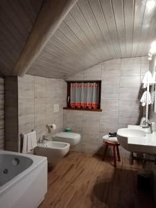 库马约尔阿索托丽亚酒店的一间带两个盥洗盆、浴缸和卫生间的浴室