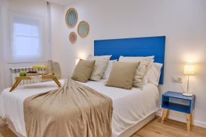 圣地亚哥－德孔波斯特拉Apartamento San Pedro的一间卧室配有一张大床和蓝色床头板