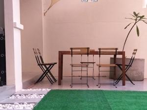 峇都丁宜Pinang Beach Cottage @ Ferringhi的一间配备有桌椅和绿色地毯的用餐室
