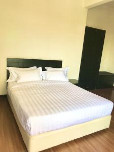 马六甲Taman Air Lagoon Resort at A921, unlimited waterpark access, Melaka的卧室配有一张带白色床单和枕头的大床。