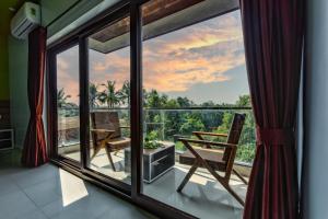 卡纳科纳Om Shanti Residence的客房设有带桌椅的大窗户。