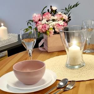 罗兹Apple Apartments - Wróblewskiego PRYWATNE MIEJSCE PARKINGOWE的一张桌子,上面放着碗,蜡烛和鲜花