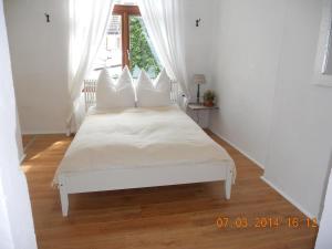 不莱梅Gästehaus La Dolce Vita的卧室配有白色的床铺和白色的枕头