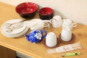 府中市Monthly Mansion Tokyo West 21 - Vacation STAY 10867的桌子上放有盘子和杯子,餐具