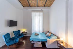 罗马Domus Aurea B&B and Suites的配有一张床和两张蓝色椅子的房间