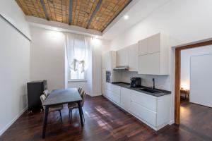 罗马Domus Aurea B&B and Suites的厨房配有白色橱柜和桌椅
