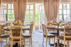 斯特拉斯堡贝斯特韦斯特PLUS别墅酒店的餐厅设有桌椅和窗户。