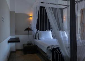 希克杜沃Temptation的卧室配有带白色枕头的天蓬床