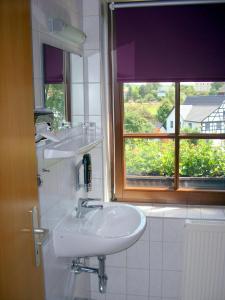 PostersteinElegant-Hotel "Zur Burg"的一间带两个盥洗盆和窗户的浴室