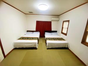 今津Shanshui House 箱館山的红色窗帘间内的两张床
