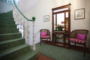曼海姆科法尔斯图本酒店的楼梯,带两把椅子和一张桌子,还有镜子