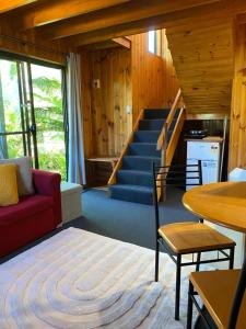 TullahThe Wombat Cottage的一间带红色沙发的客厅和楼梯