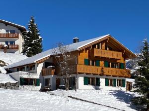 楚格Landhaus Alpenland的一座大木结构建筑,地面上积雪