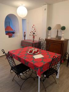 圣塞雷SUPERBE TRIPLEX MEUBLÉ TOUT CONFORT HYPER CENTRE ST CÉRÉ 3 CHAMBRES WIFI 120 M2 8 pers max的一张带红色桌布的餐桌