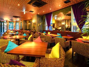 东京Comfort Inn Tokyo Roppongi的餐厅设有木桌和椅子,提供色彩缤纷的枕头