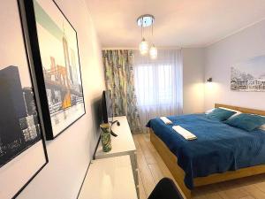 弗罗茨瓦夫Apartament z tarasem i widokiem na Odrę的一间设有蓝色床和一张桌子的小卧室