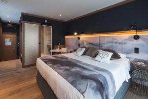 格林德尔瓦尔德冰川精品酒店 的一间卧室配有一张大床和大床头板