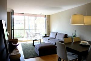 巴塞罗那格拉西亚大道太阳酒店的客厅配有沙发和桌子