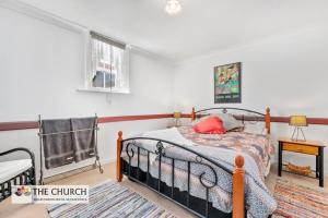 Willaston'THE CHURCH' Guest Home, Gawler Barossa Region的一间卧室配有一张红色枕头的床