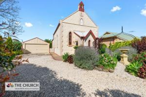 Willaston'THE CHURCH' Guest Home, Gawler Barossa Region的一座教堂,在房子前面有一个碎石场