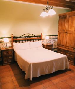 Corral de AyllónApartamentos Los Rosales de Isabel的卧室配有一张白色大床和2个床头柜