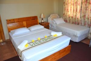 安塞奥潘礁石假日公寓的两张位于酒店客房的床,上面有鲜花