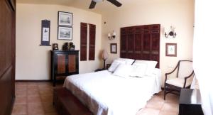 卡门港Chalet Nº 7 Tajinaste的卧室配有白色的床和椅子