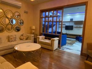 拉合尔Burj Al Bahria Town Luxury Suites的客厅配有沙发和桌子