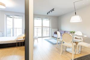 比亚韦斯托克Apartament Koncertowy的配有一张床和一张桌子及椅子的房间