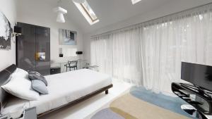 米尔顿凯恩斯南屋旅舍的一间卧室设有一张床和一个大窗户
