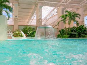 百乐费利克斯莲花千卡温泉Spa豪华度假酒店的一座大型游泳池,在一座建筑中设有喷泉