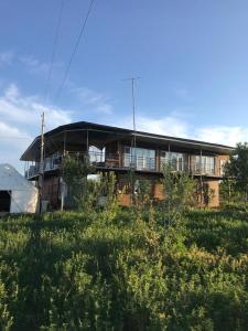 博孔巴耶沃Guest house and yurt camp "Aktan"的一座大型建筑,在田野上设有阳台