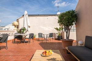 巴塞罗那Decô Apartments Barcelona-Eixample的庭院配有桌椅和一碗水果
