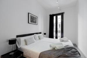 巴塞罗那Decô Apartments Barcelona-Eixample的白色的卧室设有一张大床和一个窗户