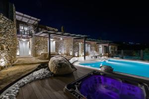 米克诺斯城Beyond Beachfront Super Paradise Villa的夜间带游泳池的别墅